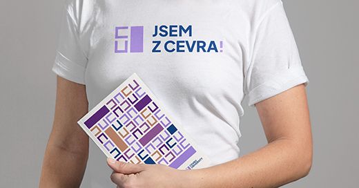 Člověk v tričku Jsem z CEVRA drží tištěný materiál se vzorem značky